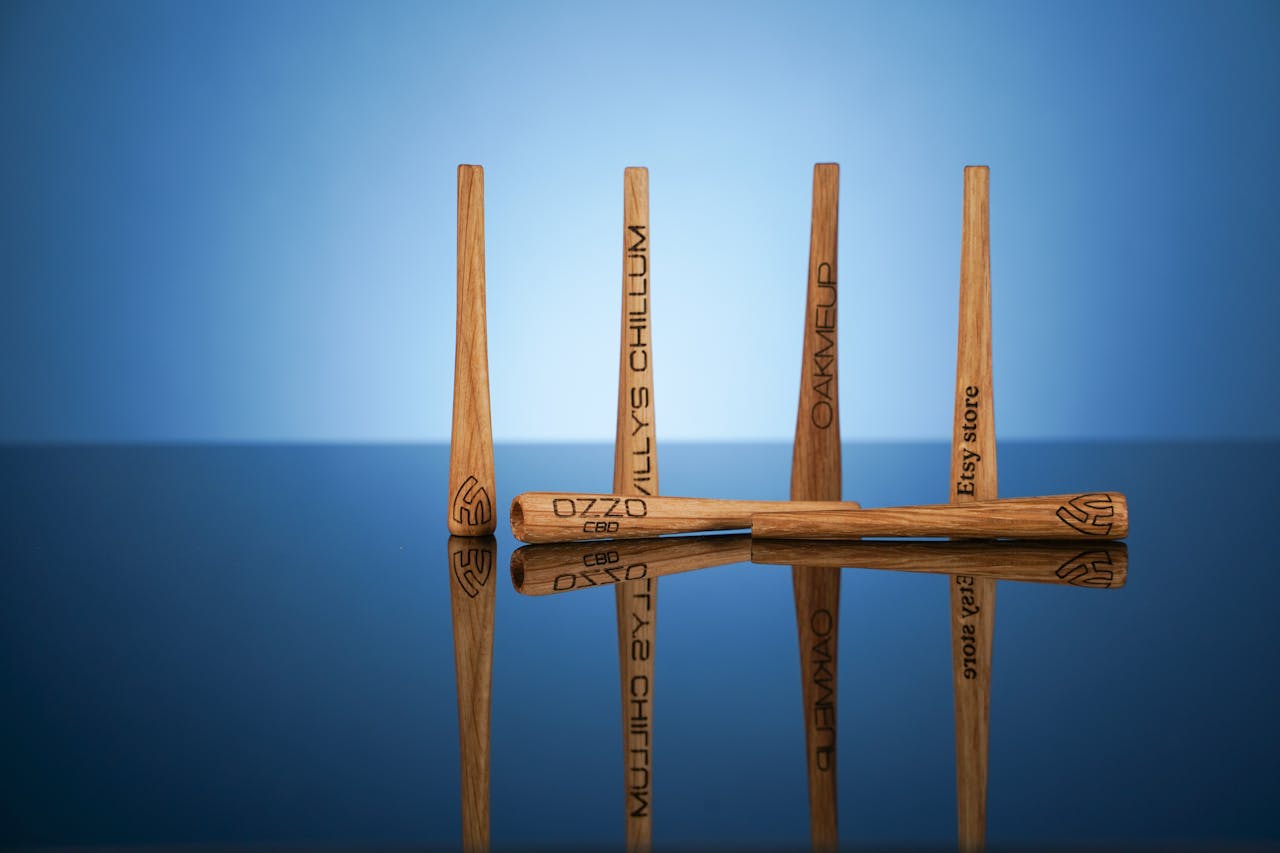 Close-up of engraved wooden sticks with reflections on a glossy surface, ideal for product design visuals.
