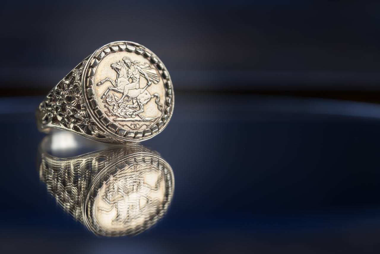 Detailed close-up of a reflective silver ring featuring a knight engraving, ideal for jewelry lovers.